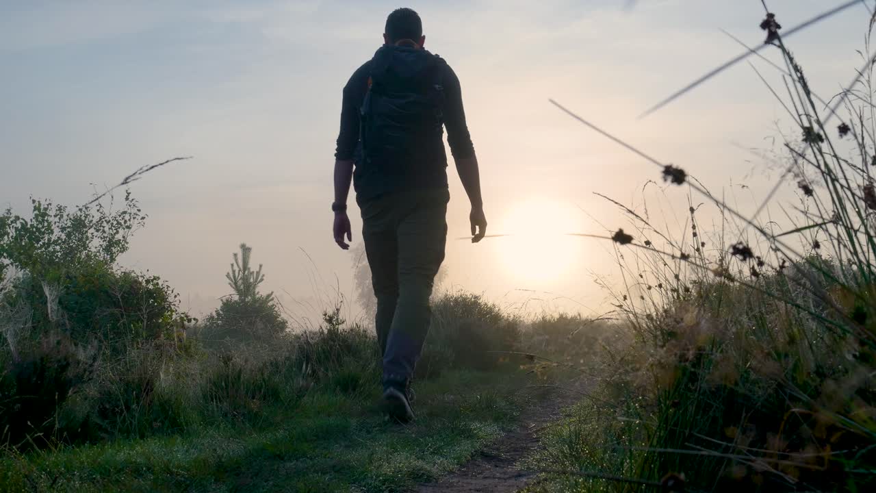 Hiker in a Misty Sunrise Landscape