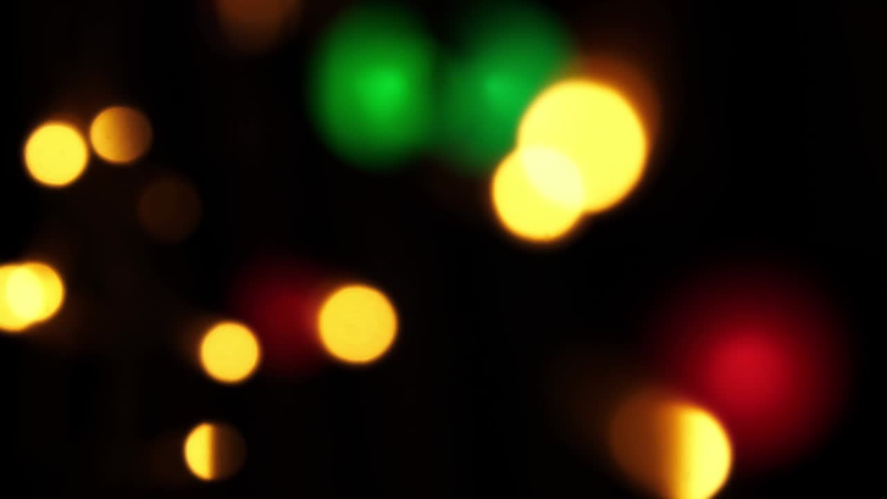 fondo bokeh abstracto en movimiento. brillantes, borrosas partículas multicolores, luces. bokeh brillante de guirnaldas en fondo oscuro. telón de fondo festivo de año nuevo o navidad
