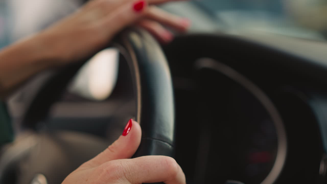 mujer gira el volante del coche a los lados moviendo los dedos