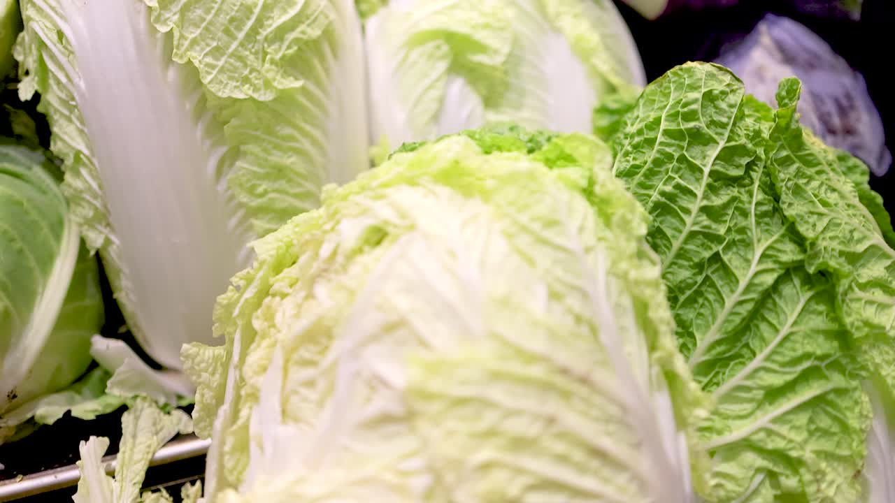Crisp lettuce and red cabbage arranged under bright lighting in a supermarket setting, highlighting freshness and vibrant colors