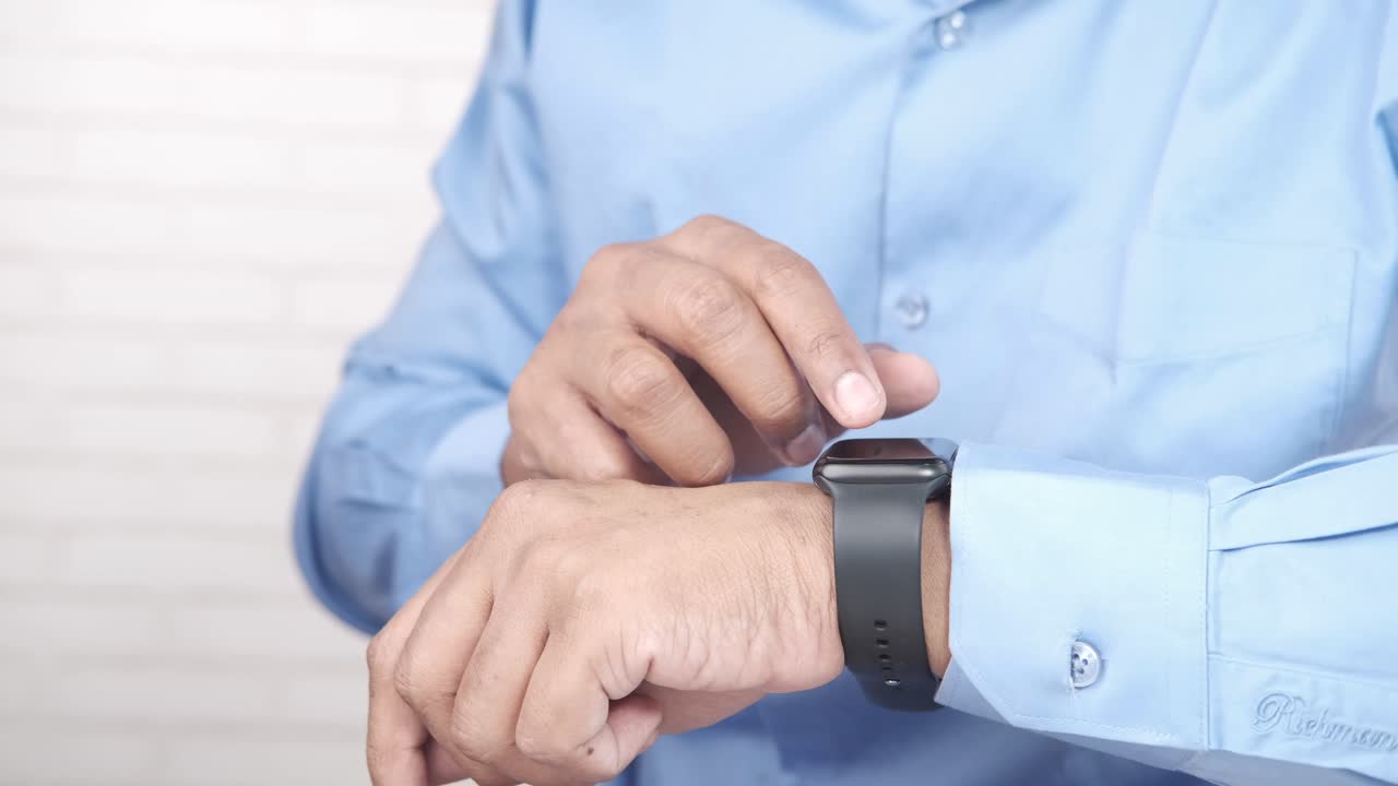 hombre comprobando la hora en el reloj inteligente