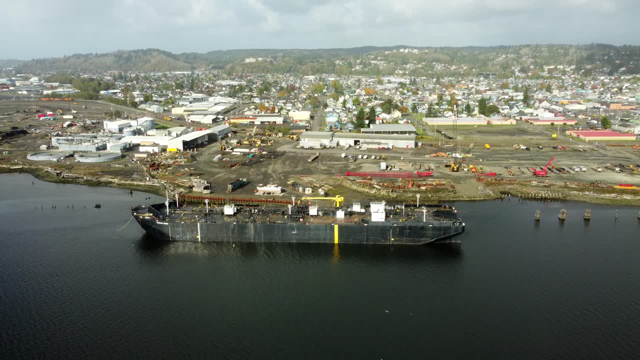 US, WA, Aberdeen, 2025-10-29 - Drone view of an a ship in an industrial area in the city in fall