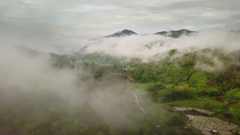 vista aérea volando sobre la exuberante montaña verde de la selva tropical con nubes de lluvia durante la temporada de lluvias en el parque nacional reservado de la montaña doi phuka en el norte de tailandia