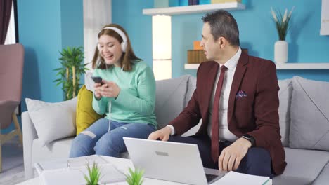 el padre está enojado con su hija que baila y canta porque no puede hacer su trabajo.