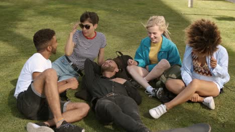 lounging friends on meadow in park