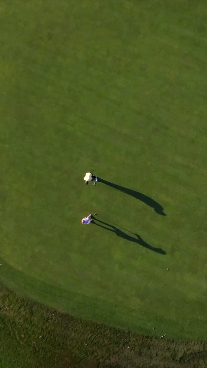 Golfers on a green golf course