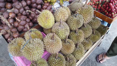 Fruta-Durian-Exhibida-En-Una-Frutería-Local-En-El-Sudeste-Asiático,-Vendedor-Y-Comprador