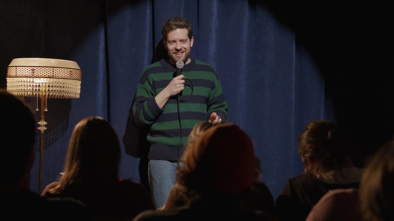 Giovane Uomo che si Esibisce in un Monologo di Stand-up Comedy Davanti al Pubblico