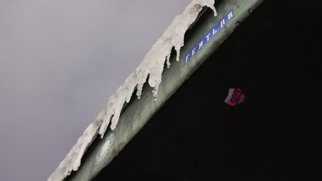 Winter-in-the-mountains,-frozen-roof,-water-melting-from-icicles,-Sniezka-mount,-slow-motion