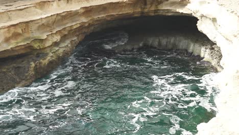 Mediterranean-Sea-Filling-St-Peter’s-Pool-Stone-Beach-Cave-on-Very-Bright-Sunny-Day