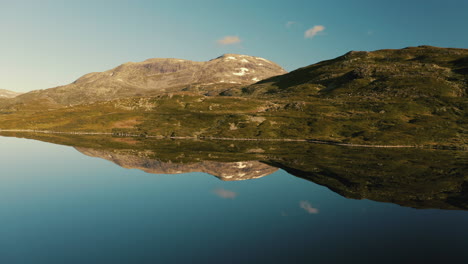 Perfekte-Bergreflexion-Auf-Dem-Seewasser-In-Norwegen-An-Einem-Sonnigen-Tag---Kamerafahrt