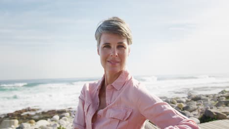 Portrait-of-a-Caucasian-woman-enjoying-free-time-by-the-sea-on-a-sunny-day