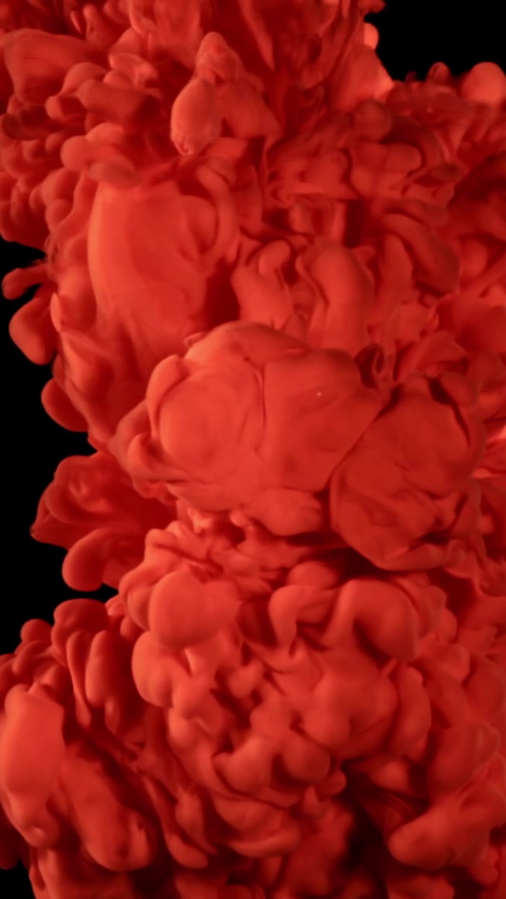 Vibrant Red Ink Spreading in Water on Black Background