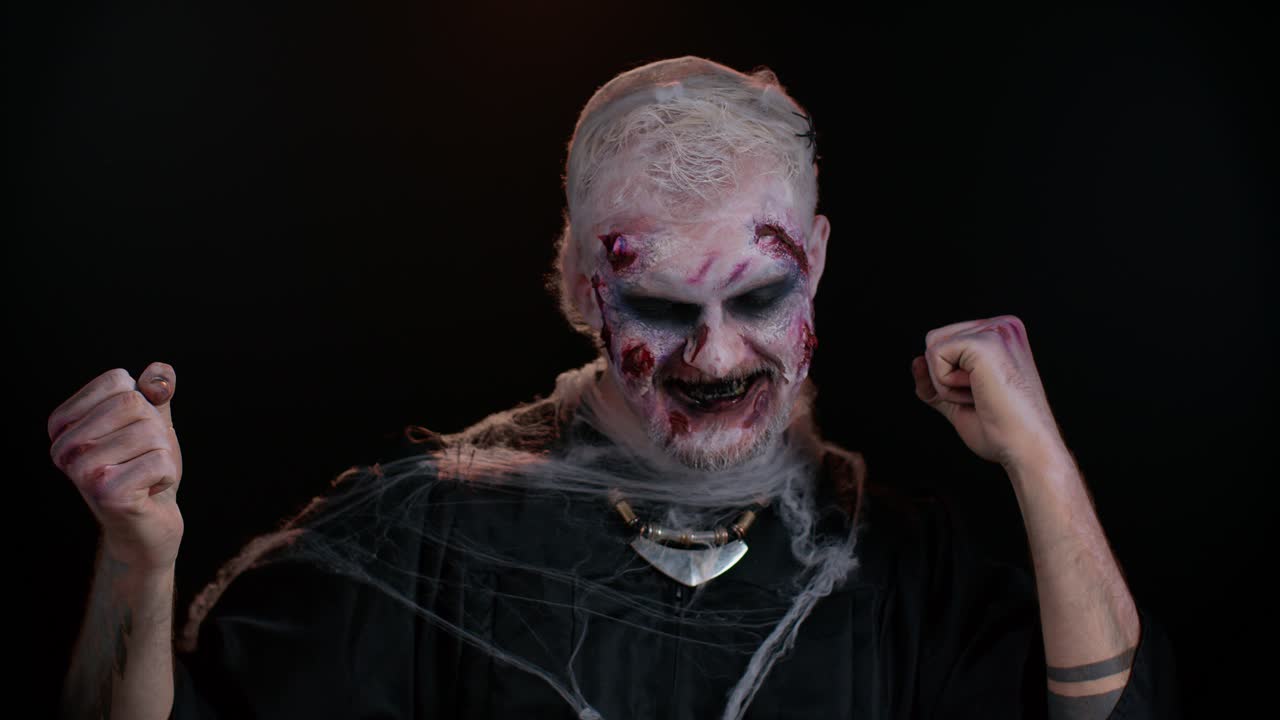 hombre siniestro disfrazado de halloween zombie loco escuchando música, sonriendo bailando a la música disco