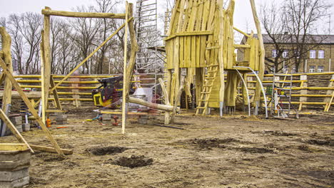 toma estática de los trabajadores de la construcción ocupados construyendo un parque infantil de madera en un lapso de tiempo en un día nublado