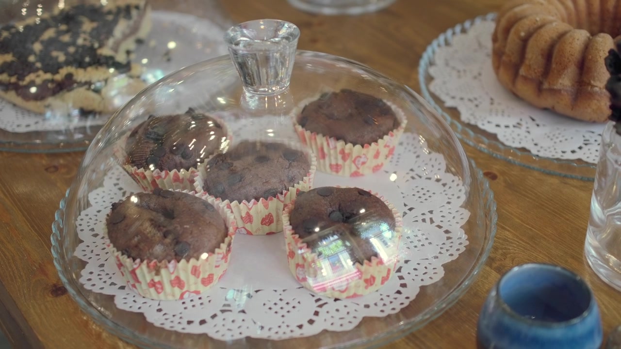 Muffin al cioccolato sotto una campana di vetro su un tavolo di legno