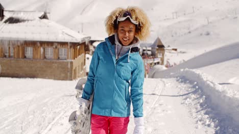 Sonriente-Mujer-Joven-Y-Bonita-Llevando-Una-Tabla-De-Snowboard