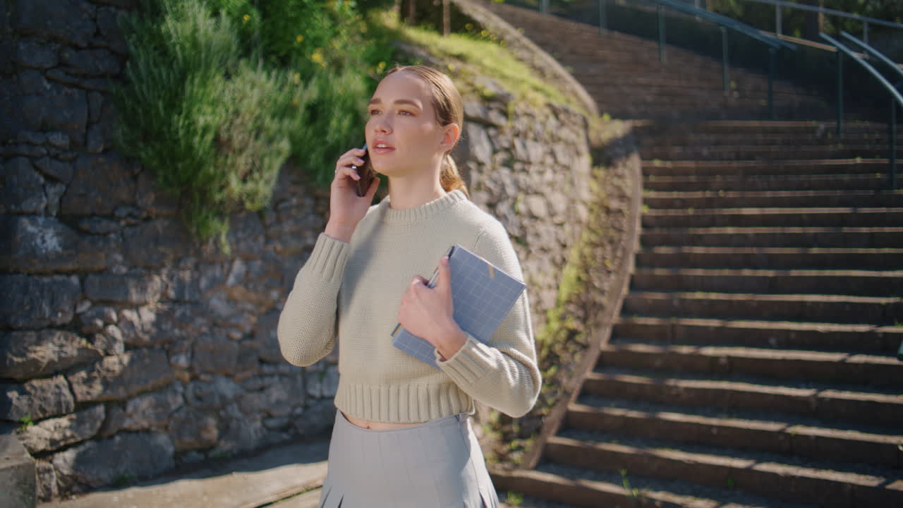 Happy lady calling smartphone strolling staircase at city closeup
