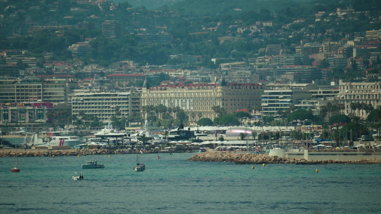 Ikonische Stadtansicht von Cannes entlang der Mittelmeerküste, mit Luxusyachten, die im geschäftigen Hafen vor Anker liegen, und historischen Gebäuden, Cannes, Frankreich