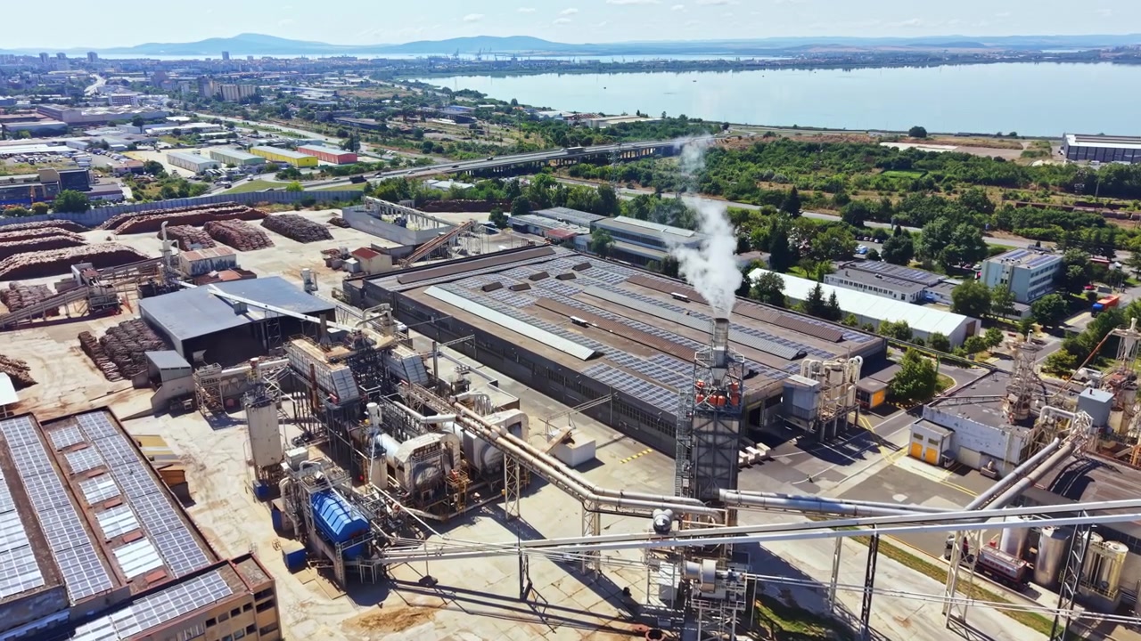 Area industriale con fabbriche e impianti di lavorazione vicino a un fiume in una giornata di sole