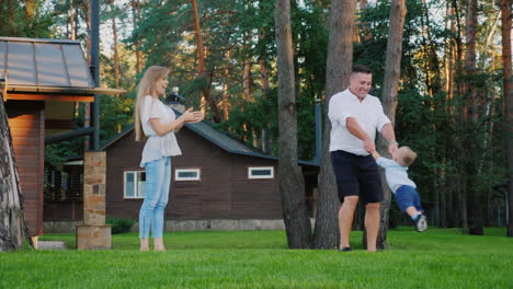 A-Happy-Family-In-The-Yard-Of-Your-House-The-Daddy-Turns-The-Boy's-Boy-Around-My-Mother-Is-Standing-