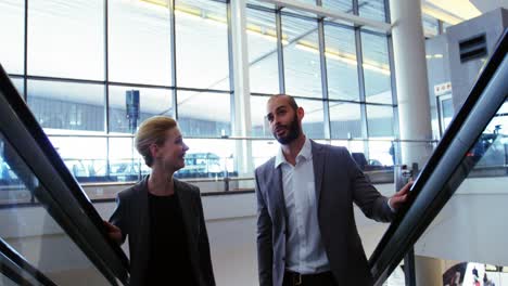 Business-people-interacting-on-an-escalator