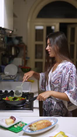 mujer cocinando verduras en la cocina por la noche