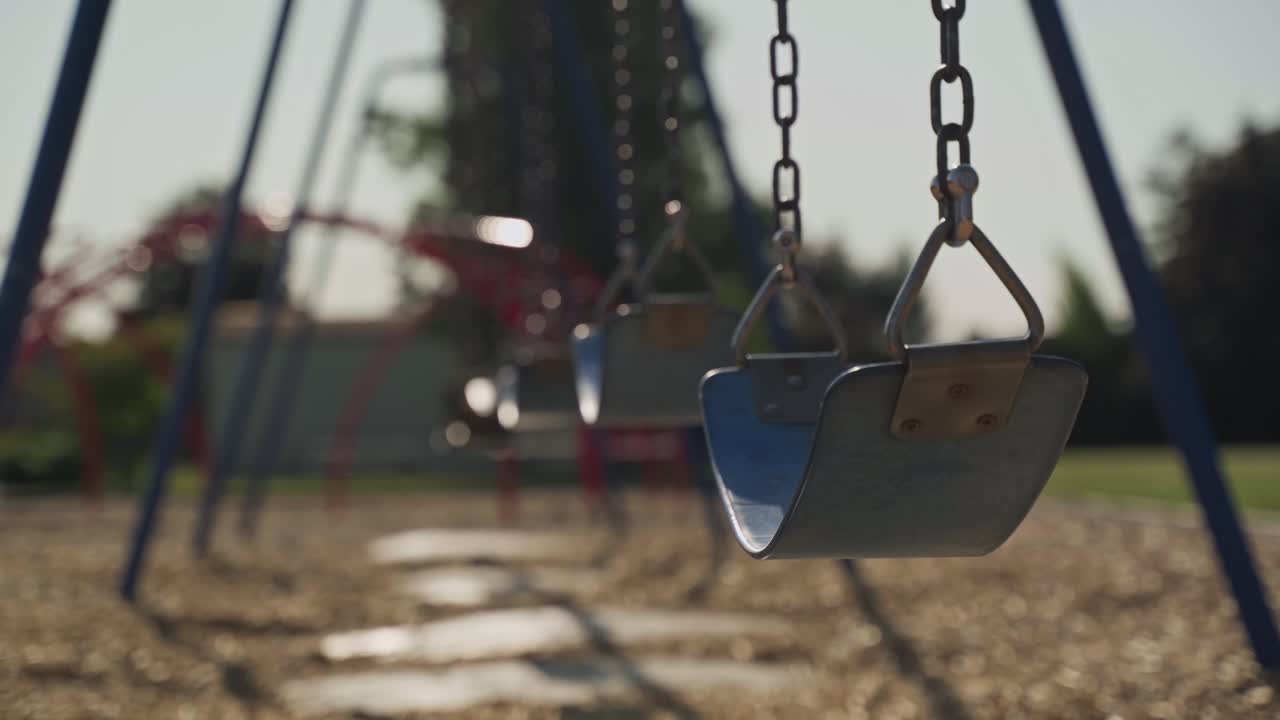Vacant playground swing set at golden hour