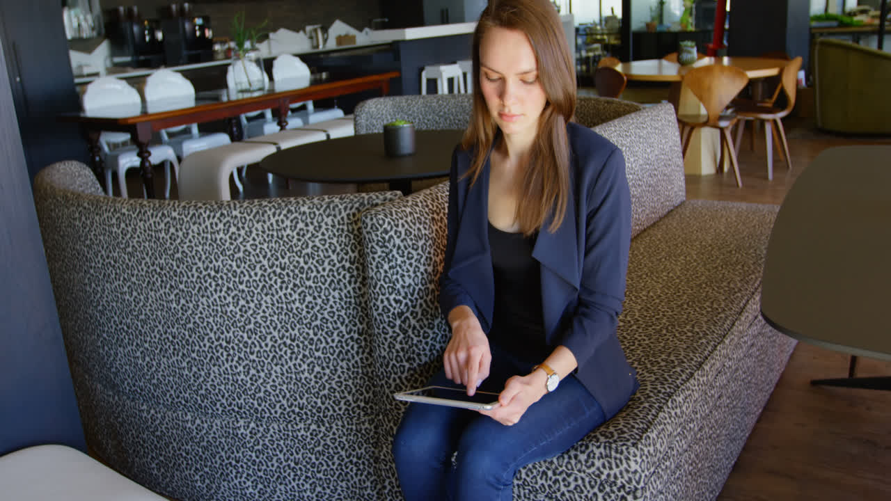 Front view of young caucasian businesswoman working on digital tablet in a modern office 4k