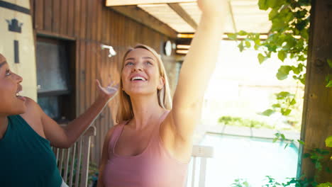 Smiling-Female-Friends-Outdoors-At-Home-Making-Video-Call-On--Mobile-Phone-Together