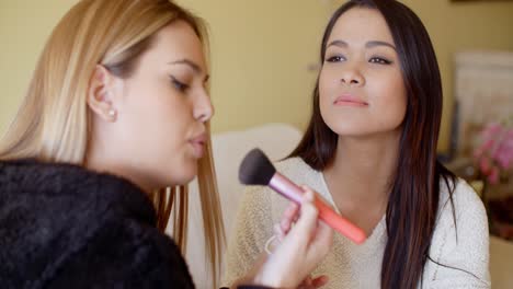 smiling woman getting makeup applied