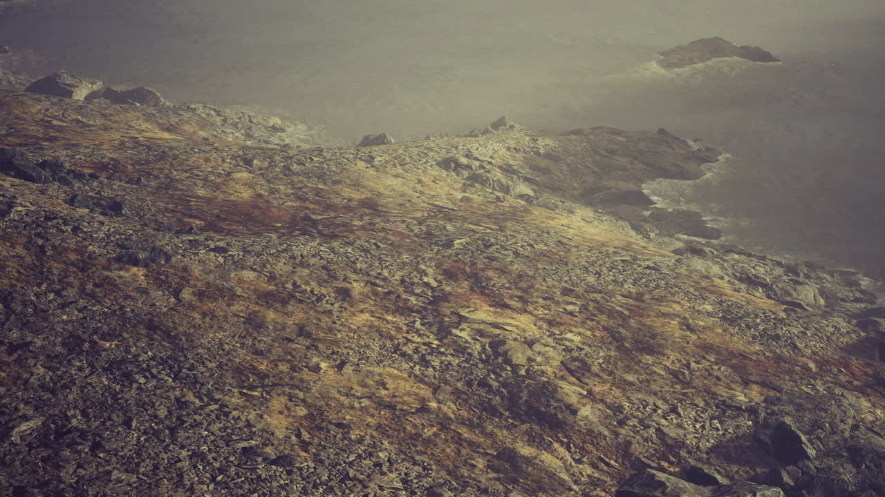 Rocky coastline at sunrise with gentle waves lapping at the shore