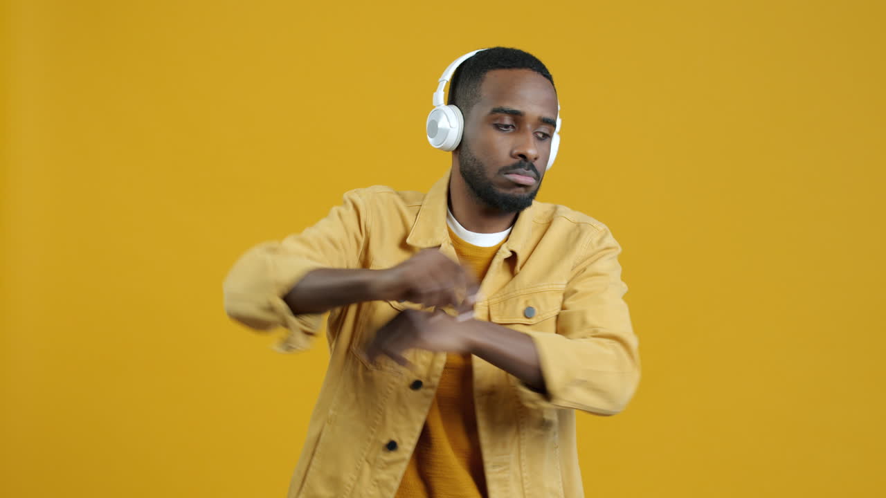 Man Dancing with Headphones on a Yellow Background