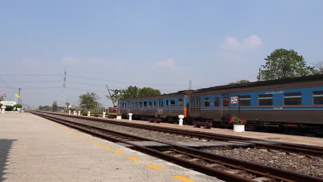 a train moves across tracks at a small station.