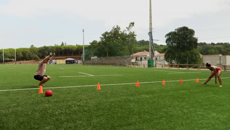people training with cones on a football field