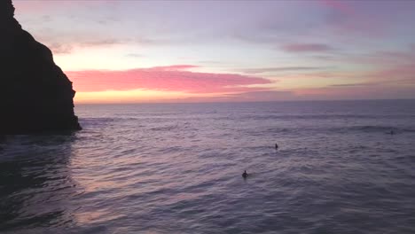 Silueta-De-Acantilado-Y-Surfistas-Surfeando-Al-Atardecer-En-Cornualles