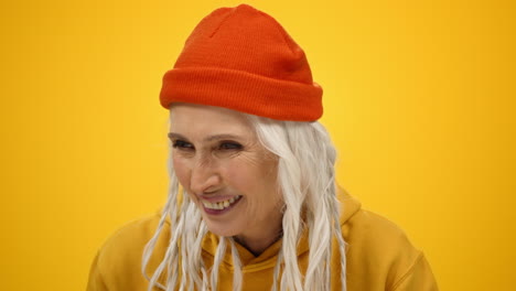 Cheerful-old-woman-enjoying-leisure-in-studio.-Happy-lady-telling-story-indoors.