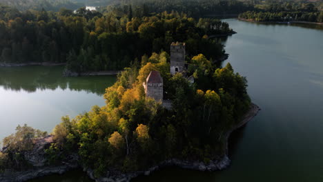 órbita aérea alrededor de las ruinas del castillo de ottenstein, llamaradas solares cinematográficas y largas sombras en el agua