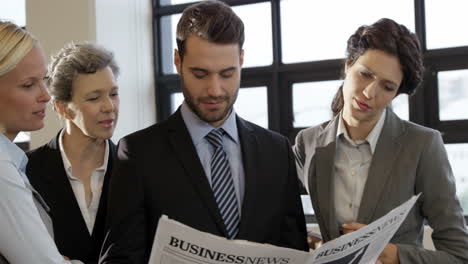 business people looking at newspaper