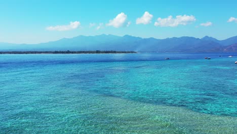 beautiful sea texture with crystal emerald water of turquoise lagoon around seashore of tropical islands on a bright blue sky background in thailand