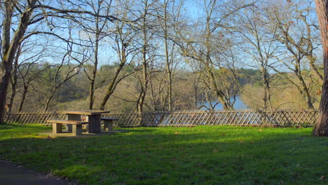 Eingezäunter-Park-Picknickplatz-Mit-Holztisch-Und-Stühlen-Vor-Einem-Hintergrund-Wunderschöner-Natur-Während-Des-Tages