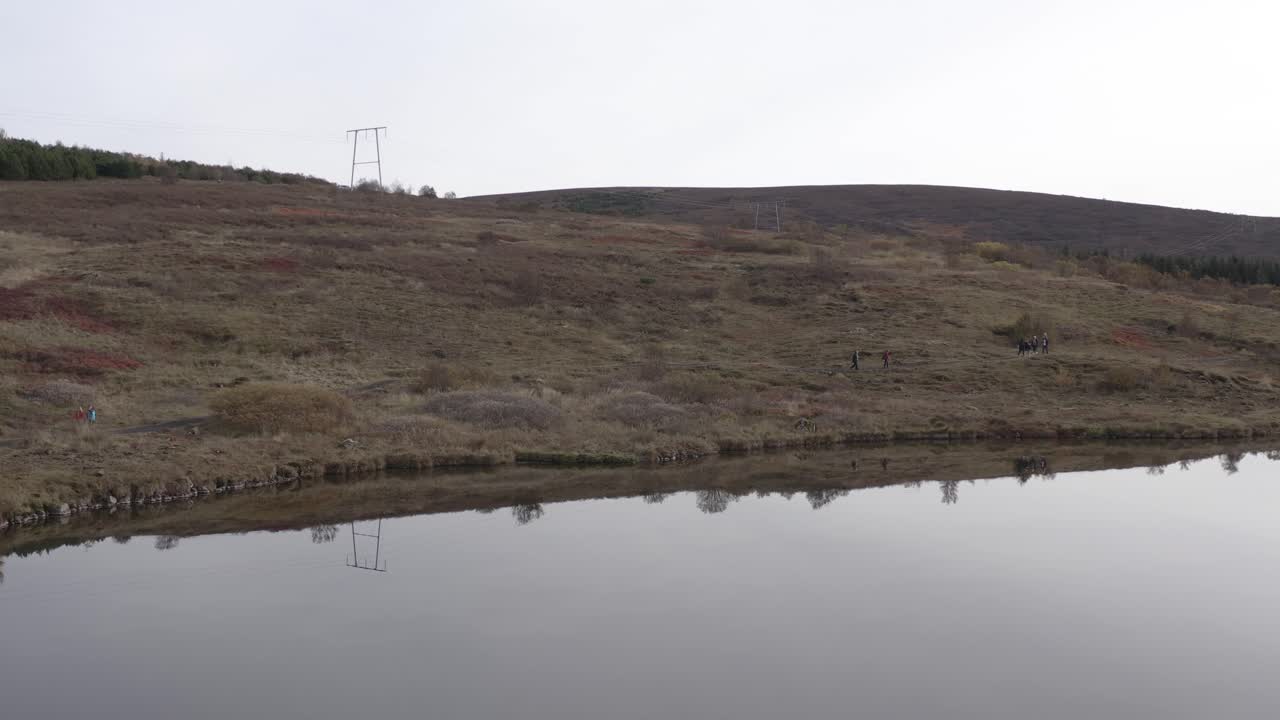 평평한 물과 해안을 걷는 사람들이 있는 vífilsstaðavatn 호수의 공중