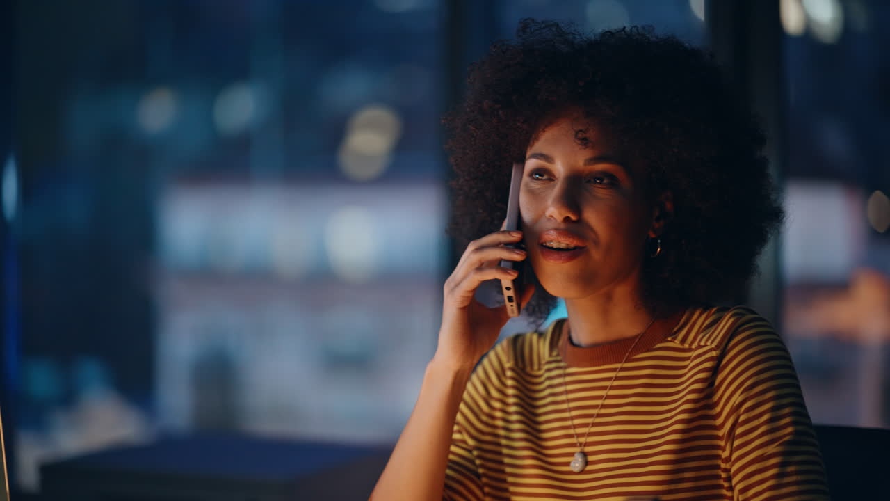 businesswoman talking smartphone at evening workplace closeup smiling