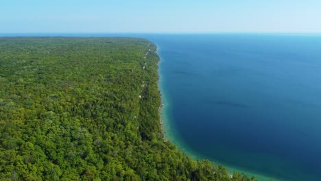 zipline drone shot of the steep side of a lush boreal forest beside georgian bay located in ontario, canada