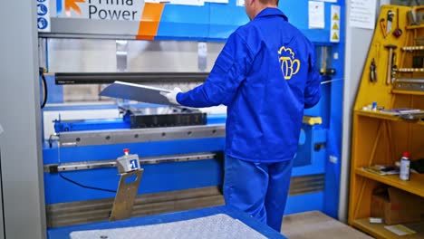 interior of industrial working place at factory. robotic factory line for processing and cutting packing materials for goods. worker at plant in blue uniform. industrial concept.