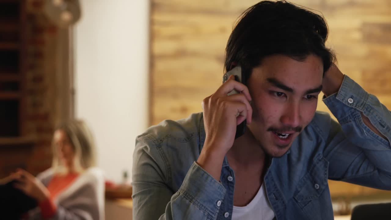 혼성 인종 남자가 그의 아파트에서 집중하고 일하고 있습니다.