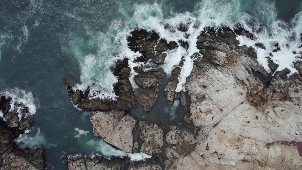 Vista aerea a volo d'uccello di onde oceaniche che si infrangono tra le rocce