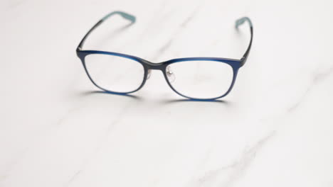 focusing and slowly zooming on a pair of eyeglasses placed on top of a table