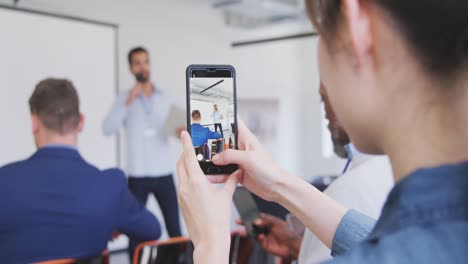 businesswoman taking videos of meeting in conference room