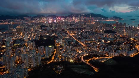 overlooking illuminated kowloon night cityscape skyscrapers fast busy city life aerial orbit right hyperlapse